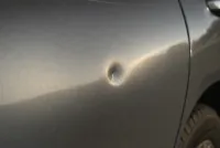 Close-up of a dent on the front right wing matching prior damage